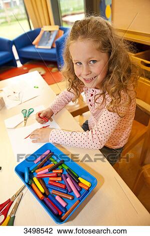 Young girl drawing with wax crayons, elevated view View Large Photo Image Stock Image - Young girl drawing with wax crayons, elevated view . Fotosearch