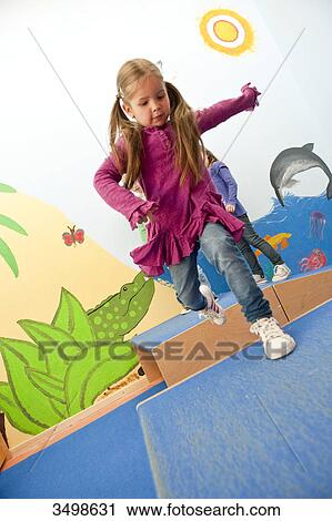 Stock Image - Young girl jumping over boxes, low angle view . Fotosearch