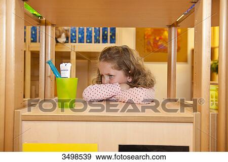 Young girl leaning against a shelf beside a toothbrush holder View Large Photo Image Stock Photo - Young girl leaning against a shelf beside a toothbrush holder . Fotosearch