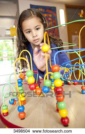 Picture - Young girl playing with an educational toy . Fotosearch