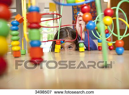 Stock Photo - Young girl playing with an educational toy . Fotosearch