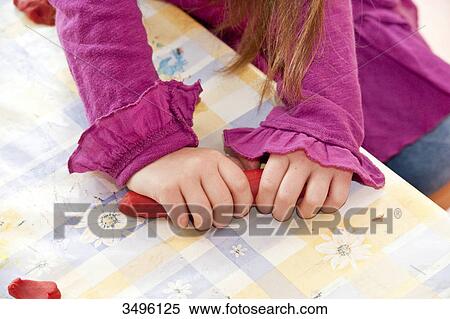 Stock Photography - Young girl playing with modeling clay, elevated view . Fotosearch