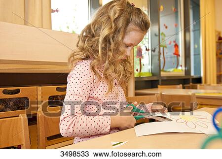 Young girl using scissors to cut paper, low angle view View Large Photo Image Stock Image - Young girl using scissors to cut paper, low angle view . Fotosearch