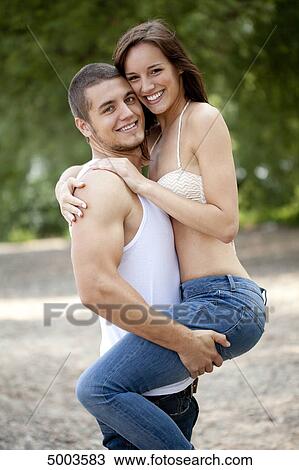 Young man carrying woman outdoors View Large Photo Image Stock Image - Young man carrying woman outdoors . Fotosearch