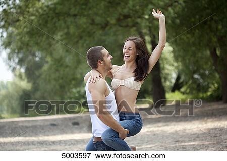 Young man carrying woman outdoors View Large Photo Image Stock Photo - Young man carrying woman outdoors . Fotosearch