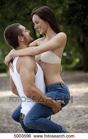Young man carrying woman outdoors View Large Photo Image Stock Photograph - Young man carrying woman outdoors . Fotosearch