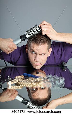 Stock Image - Young man dressing his hair . Fotosearch