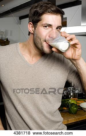 Young man drinking milk View Large Photo Image Stock Photo - Young man drinking milk . Fotosearch