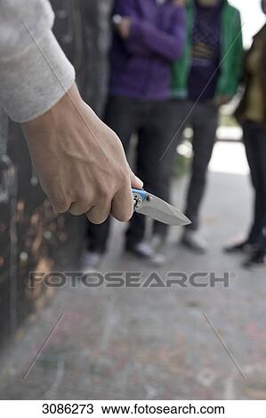 Young man holding a pocketknife, teenager in the background View Large Photo Image Stock Image - Young man holding a pocketknife, teenager in the background . Fotosearch