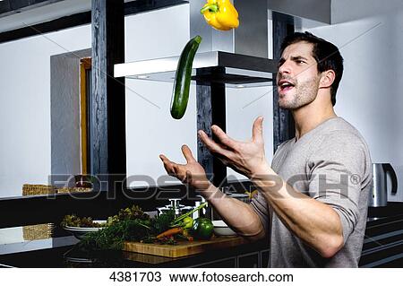 Young man juggling with cucumber and yellow pepper View Large Photo Image Stock Image - Young man juggling with cucumber and yellow pepper . Fotosearch