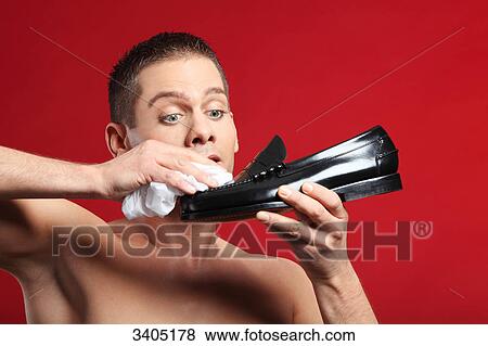 Young man polishing a shoe View Large Photo Image Stock Photo - Young man polishing a shoe . Fotosearch