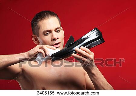 Young man polishing a shoe View Large Photo Image Stock Photography - Young man polishing a shoe . Fotosearch