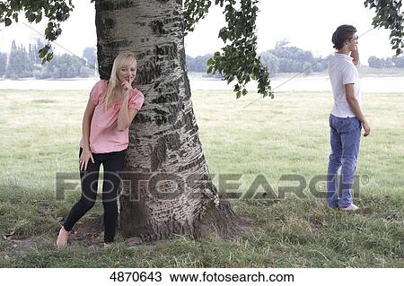 Young woman and man playing hide and seek View Large Photo Image Stock Image - Young woman and man playing hide and seek . Fotosearch