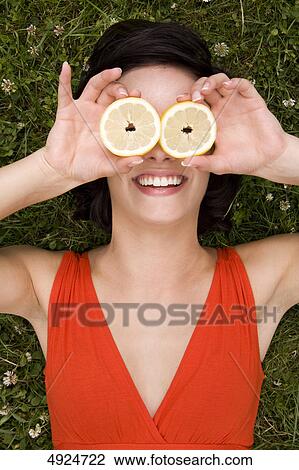 Young woman covering her eyes with lemon slices View Large Photo Image Stock Image - Young woman covering her eyes with lemon slices . Fotosearch
