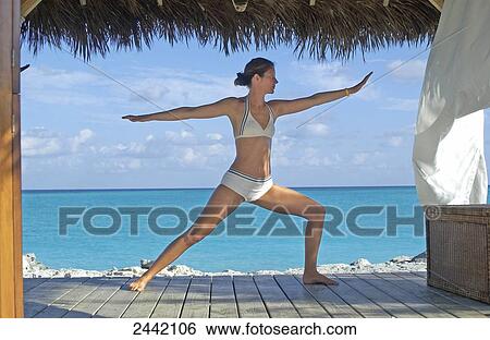 Stock Photograph - Young woman exercising in resort . Fotosearch