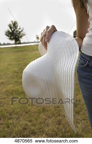 Young woman in jeans and hat in meadow View Large Photo Image Stock Photography - Young woman in jeans and hat in meadow . Fotosearch