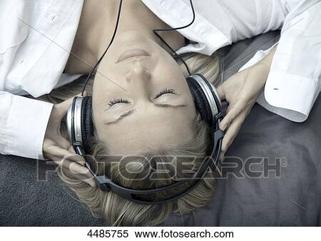 Young woman listening to music with headphones View Large Photo Image Stock Photography - Young woman listening to music with headphones . Fotosearch