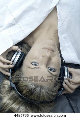 Stock Photography - Young woman listening to music with headphones . Fotosearch