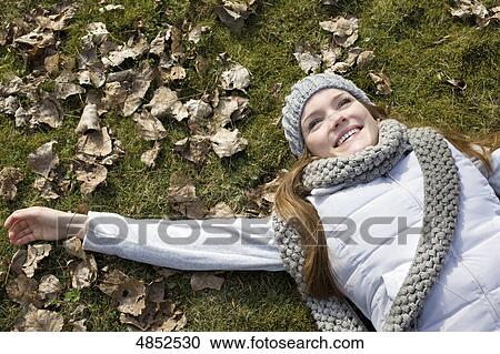 Young woman lying in leaves View Large Photo Image Stock Image - Young woman lying in leaves . Fotosearch
