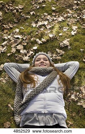 Stock Photo - Young woman lying in leaves . Fotosearch
