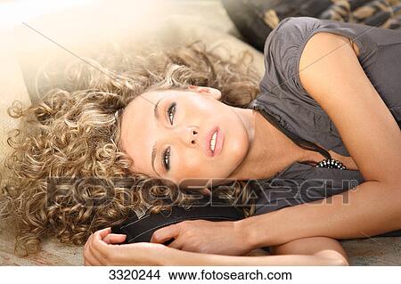 Picture - Young woman lying, portrait . Fotosearch