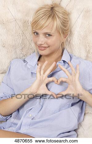 Stock Photography - Young woman making heart with her hands . Fotosearch