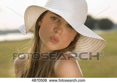 Stock Photo - Young woman pouting mouth outdoors . Fotosearch
