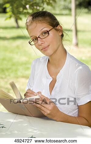 Young woman reading book outdoors View Large Photo Image Stock Photo - Young woman reading book outdoors . Fotosearch