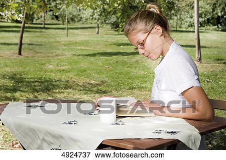Young woman reading book outdoors View Large Photo Image Stock Photo - Young woman reading book outdoors . Fotosearch