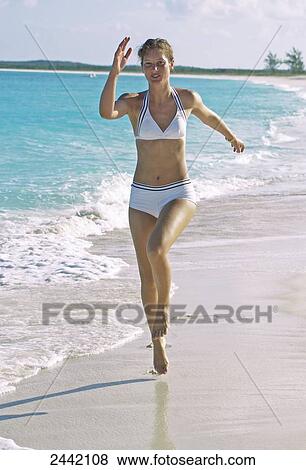Stock Photo - Young woman running on beach . Fotosearch