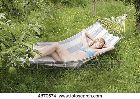 Picture - Young woman wearing bikini lying in hammock . Fotosearch