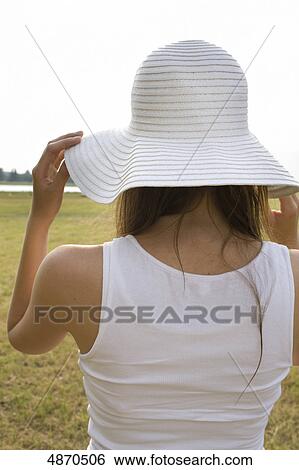 Stock Photograph - Young woman wearing hat outdoors . Fotosearch