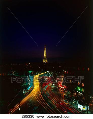 Stock Image - Aerial view of traffic on road in city at night, Eiffel Tower, Paris, Ile-de-France, France . Fotosearch