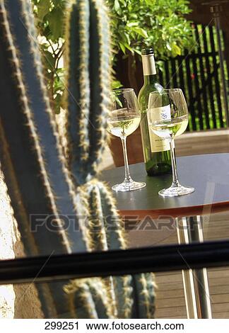 Stock Image - Bottle and glasses of white wine on table . Fotosearch