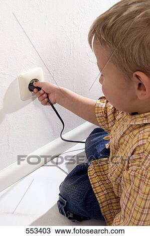 Boy holding electric plug in socket View Large Photo Image Stock Image - Boy holding electric plug in socket . Fotosearch