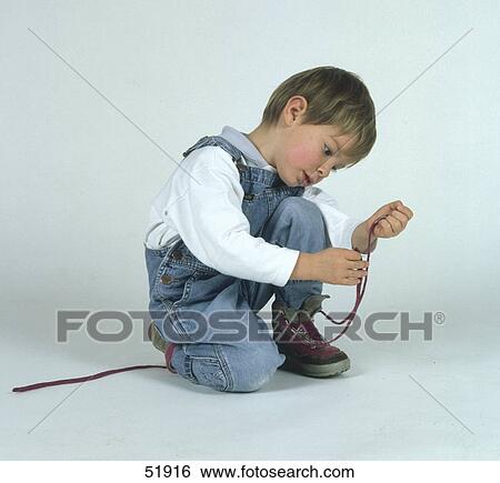 Boy knotting shoes View Large Photo Image Stock Photograph - Boy knotting shoes . Fotosearch