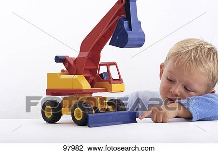 Stock Image - Boy playing with toy digger . Fotosearch