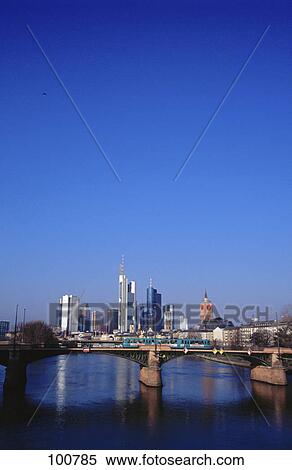 Stock Photography - Bridge across river with skyscrapers in background, Ignatz Bubis Bridge, River Main, Frankfurt, Hesse, Germany . Fotosearch