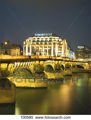 Stock Photography - Bridge lit up at night with department store in background, La Samaritaine, Seine River, Paris, France . Fotosearch
