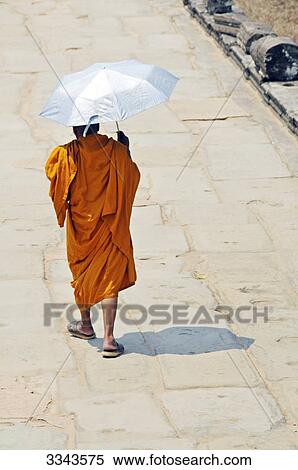 Stock Photography - Buddhist monk with umbrella, Angkor, Cambodia, rear view . Fotosearch