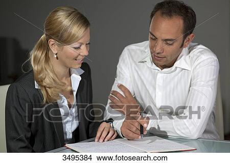 Picture - Business partner looking at notes . Fotosearch
