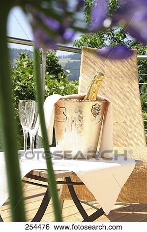 Champagne bottle in a champagne bucket on a table View Large Photo Image Stock Photograph - Champagne bottle in a champagne bucket on a table . Fotosearch