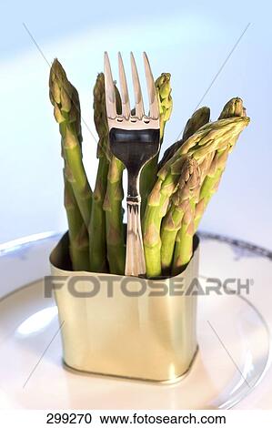 Stock Image - Close-up of asparagus and fork on plate . Fotosearch
