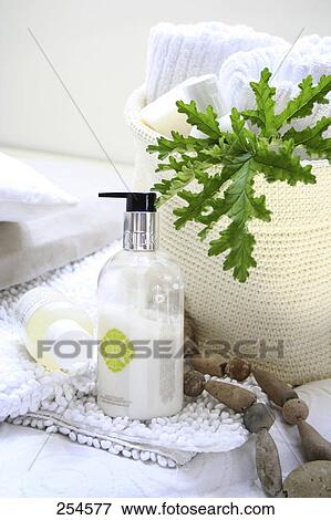 Stock Photo - Close-up of bottles of moisturizers on towel . Fotosearch