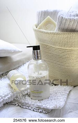 Stock Photograph - Close-up of bottles of moisturizers on towel . Fotosearch
