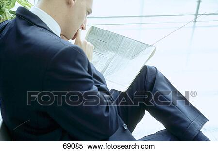 Stock Photography - Close-up of businessman reading financial newspaper . Fotosearch