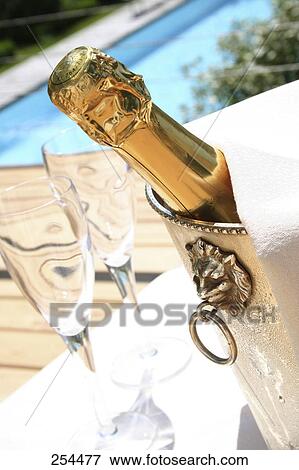 Stock Photo - Close-up of Champagne bottle in ice bucket . Fotosearch