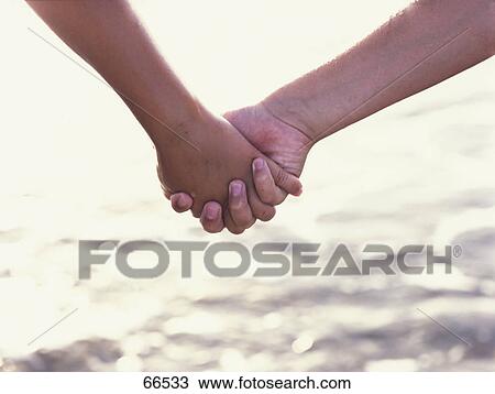 Close-up of couple holding hands View Large Photo Image Stock Image - Close-up of couple holding hands . Fotosearch