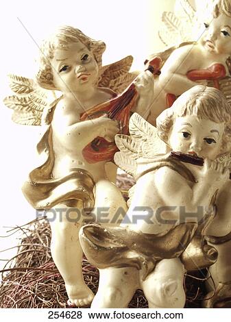 Stock Photo - Close-up of figurines of three angels playing music . Fotosearch