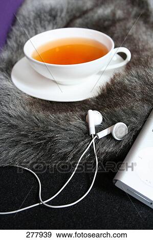 Stock Photo - Close-up of headphones and cup of black tea . Fotosearch